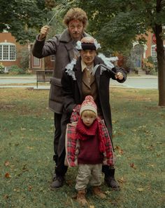 two men and a little boy standing in the grass