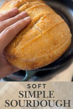 a person holding a loaf of bread in their hand with the words soft simple sourdough on it