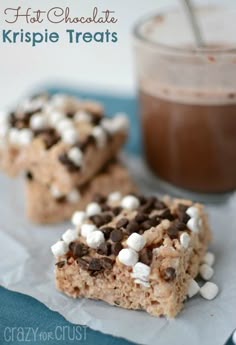 chocolate krispie treats with marshmallows on top and a cup of coffee in the background