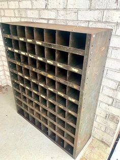 an old metal storage unit sitting in front of a brick wall