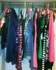 a closet filled with lots of different colored clothes