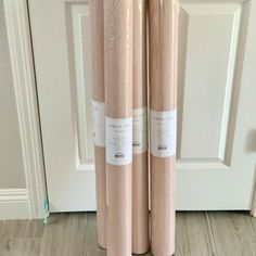 two rolls of pink colored fabric sitting next to each other in front of a door