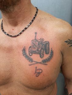 a man with a tractor tattoo on his chest