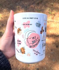 a person holding a coffee mug with stickers on it's side and saying i love all parts of me