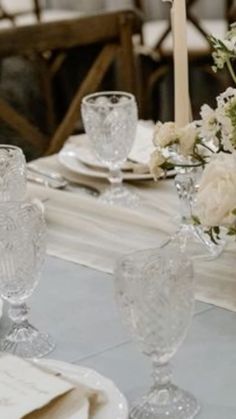 the table is set with white flowers and glassware