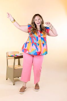 a woman standing in front of a chair with her arms up and hands out to the side