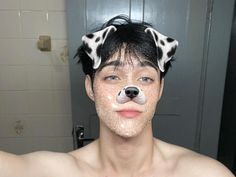 a man with black and white spots on his face is wearing a dalmatian dog hat