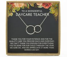 a necklace with two interlocked circles on it in a box that says, to a wonderful daycare teacher