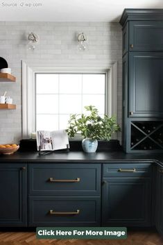 a kitchen with dark blue cabinets and white brick walls, along with an open window to let in natural light