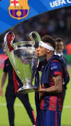 the soccer player is kissing the trophy