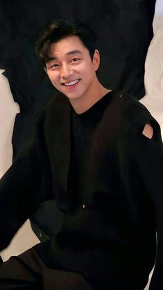 a young man sitting on top of a white chair