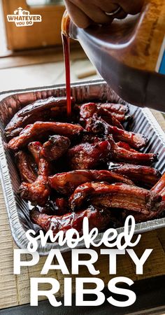 someone is pouring sauce on some meat in a tin pan with the words smoked party ribs