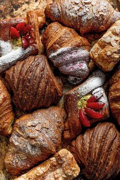 croissants with powdered sugar and red peppers on them sitting in a pile