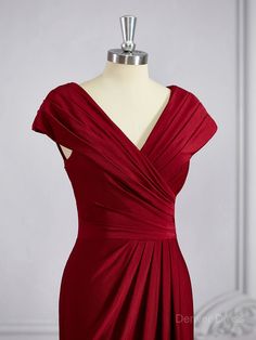 a red dress on a mannequin with a white dummy in the back ground