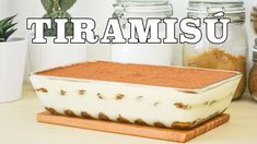 a cake sitting on top of a wooden cutting board next to jars filled with food