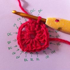 a crocheted object is sitting on top of a piece of paper next to a knitting needle