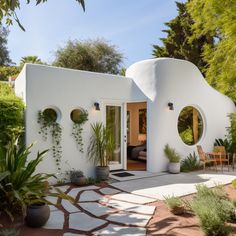 a white house with round windows and plants