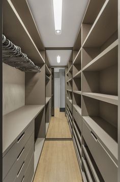 an empty walk - in closet with lots of shelves and drawers on each side,