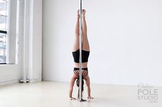 a woman standing on one leg while holding onto a pole