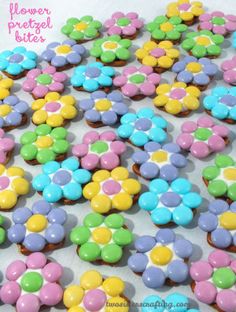 colorful cupcakes with white frosting and colored flowers on the top are ready to be eaten