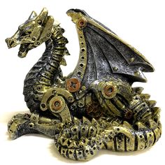 a metal dragon statue sitting on top of a white surface