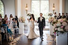 a bride and groom walking down the aisle