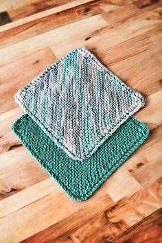 two crocheted dishcloths sitting on top of a wooden table