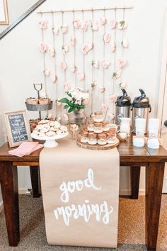 a table topped with lots of food and desserts next to a stair case filled with flowers