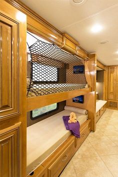 a bunk bed in a room with wooden cabinets