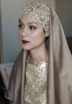 a woman wearing a head scarf and dress with gold sequins on it's head