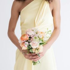 a woman in a yellow dress holding a bouquet of flowers