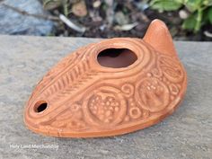 a brown vase sitting on top of a stone slab