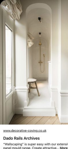 the interior of a bathroom with white walls and wood flooring, along with an open shower