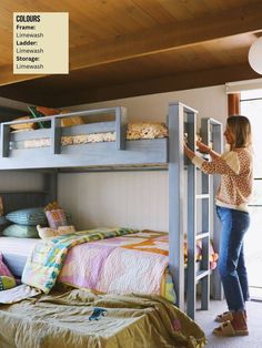 a woman standing on top of a bunk bed next to a child's bed