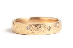 a gold wedding ring with three diamonds on the inside and outside, set in 18k yellow gold