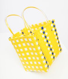 This charming 1970s style accessory features a vibrant color combo of yellow, white, and blue that screams retro chic. The durable plastic material ensures this bag will be your go-to for all your sunny day outings. With convenient plastic handles, you can easily carry all your essentials in style.Available while supplies last. Retro Yellow Beach Bag, Yellow Retro Beach Bag, Fun Yellow Rectangular Bag, Blue Plastic Summer Bag, Blue Plastic Bag For Summer, Blue Plastic Summer Bags, Blue Plastic Bags For Summer, Fun Yellow Summer Bag, Fun Yellow Summer Bags