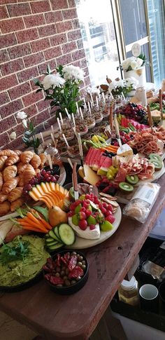 a table filled with lots of different types of food on plates and trays next to each other