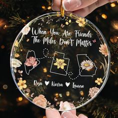 someone holding up a glass ornament with the names of their loved ones on it