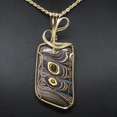 "Fordite Wire Wrapped Jewelry Description: *Designer Fordite Detroit Agate Cabochon: 40mm x 30mm Rectangle Shaped *Pendant Approximate Size: 2 3/4\" long including bail x 1 1/4\" at widest point *Free Rope Chain *Free Domestic Shipping - Arrives in Gift Box - Gift Wrapping Available The contemporary wire wrap jewelry is hand wire sculptured using 14k gold-filled wire around the recycled Fordite Detroit Agate cabochon to form this collector's item handmade wire wrap pendant statement necklace. Th Gold Agate Jewelry With Large Pendant, Gold Cabochon Agate Jewelry, Gold Agate Cabochon Jewelry, Gold Agate Jewelry With Polished Finish, Yellow Gold Agate Jewelry Gift, Yellow Gold Agate Jewelry For Gift, Fordite Jewelry, Wire Wrap Jewelry, Wire Wrap Pendant