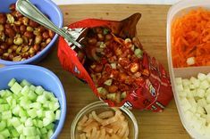 the food is prepared and ready to be eaten on the table in bowls, including carrots, celery, onions, and other vegetables