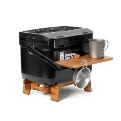 a black cooler sitting on top of a wooden table next to a bucket and cup