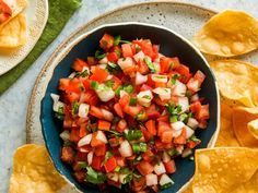 a bowl filled with salsa and tortilla chips on top of a blue plate