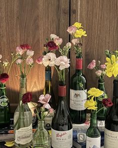 several bottles of wine and flowers on a table