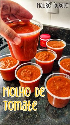 a person dipping sauce into small plastic cups on top of a counter with the words mollo de tomate in spanish