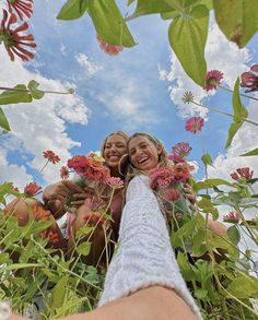 two women are taking a selfie in the middle of some wildflowers and grass