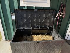 a metal box filled with hay next to a building