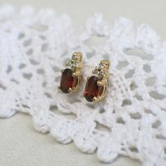 Thousands of years ago red garnet was considered to be one of the most prized possessions for Egyptian pharaohs, these beautiful gems then became popular with clergy and nobility in Rome. This rich history gives garnet a beautiful allure and makes a great pairing with diamonds. Two oval brilliant cut garnets are the focal points for these gold studs, the three round brilliant diamonds on top of each compliment the garnets perfectly. Metal: 14K Yellow Gold Garnet: 5.00 X 3.00 MM Diamonds (6): .06 Egyptian Pharaohs, Garnet And Gold, Focal Points, Gold Stud Earrings, Gold Stud, Red Garnet, Brilliant Diamond, Vintage Diamond, Gold Earrings Studs