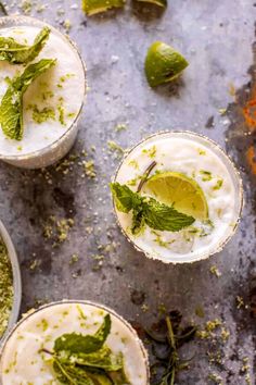 three glasses filled with mojitas and garnished with mint