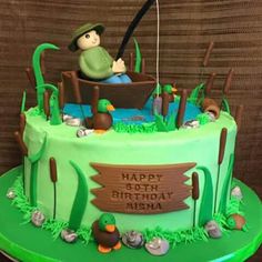 a green birthday cake with a man in a boat on the lake and fishing rods