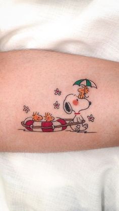 a person with a tattoo on their arm that has a cartoon dog riding a sleigh